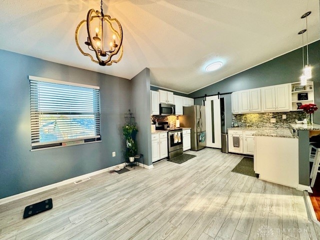 kitchen featuring white cabinetry, vaulted ceiling, stainless steel appliances, and decorative light fixtures