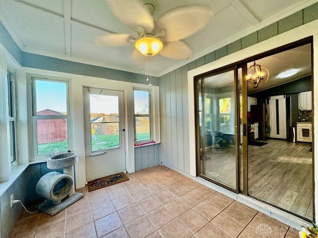 doorway featuring crown molding, light tile patterned floors, and ceiling fan