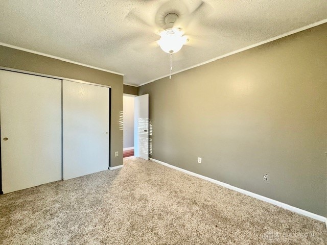 unfurnished bedroom featuring a closet, carpet floors, a textured ceiling, and ceiling fan