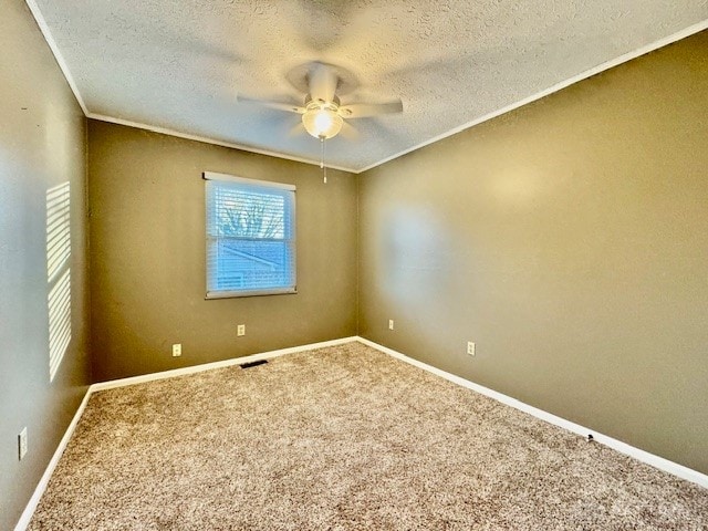 spare room featuring carpet, crown molding, a textured ceiling, and ceiling fan