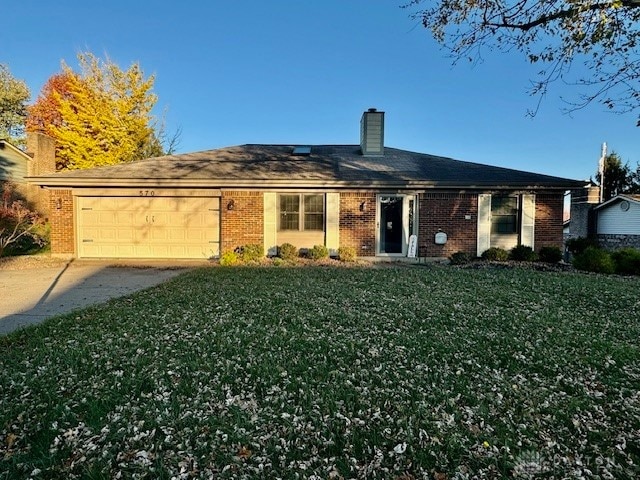 back of house with a lawn and a garage