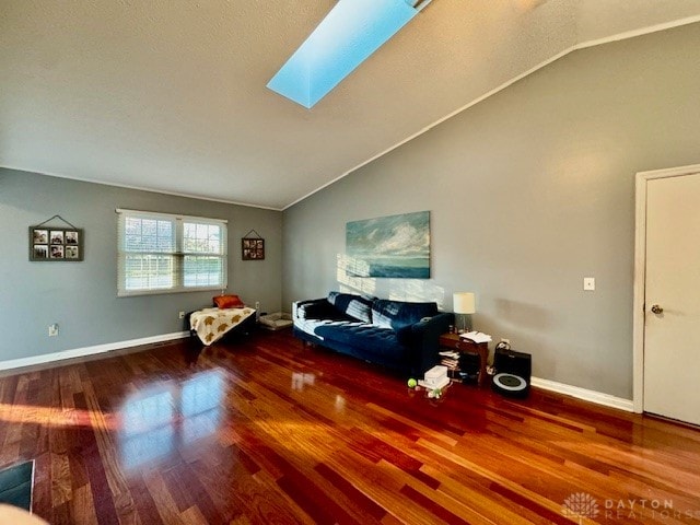 living area featuring lofted ceiling with skylight, crown molding, and wood-type flooring