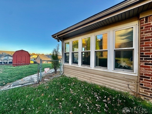 view of side of property featuring a yard and a storage shed