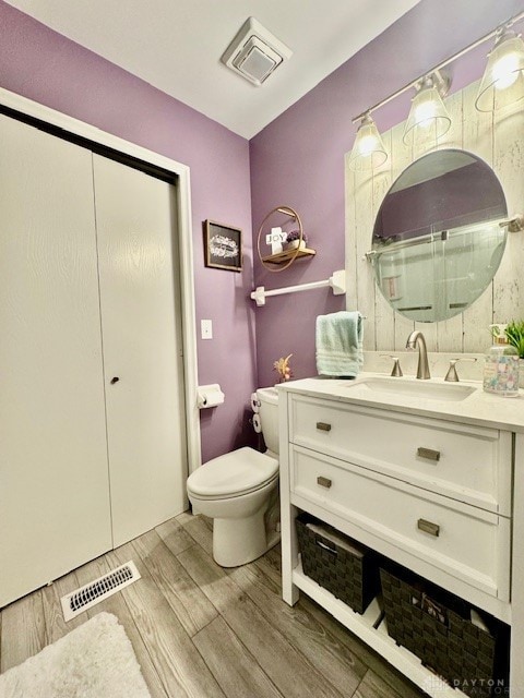 bathroom with vanity, toilet, wood-type flooring, and walk in shower