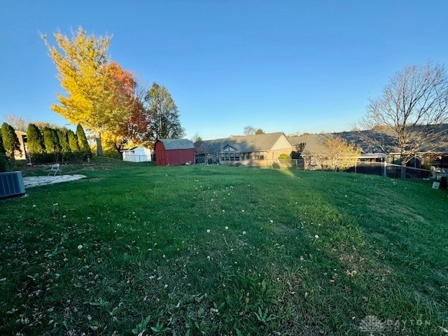 view of yard featuring a shed and central AC unit