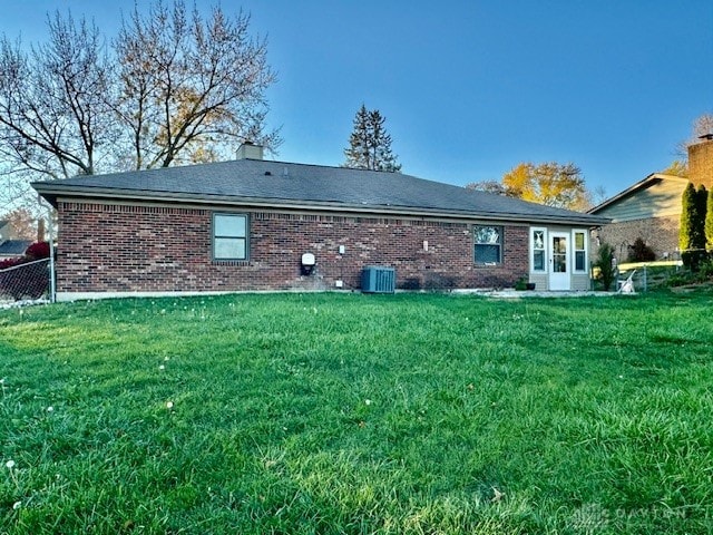 back of house featuring central AC and a lawn