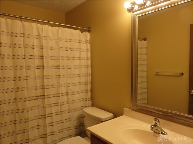 bathroom featuring a shower with curtain, vanity, a textured ceiling, and toilet