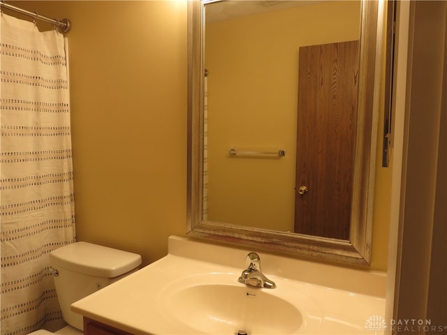 bathroom featuring vanity, toilet, and walk in shower