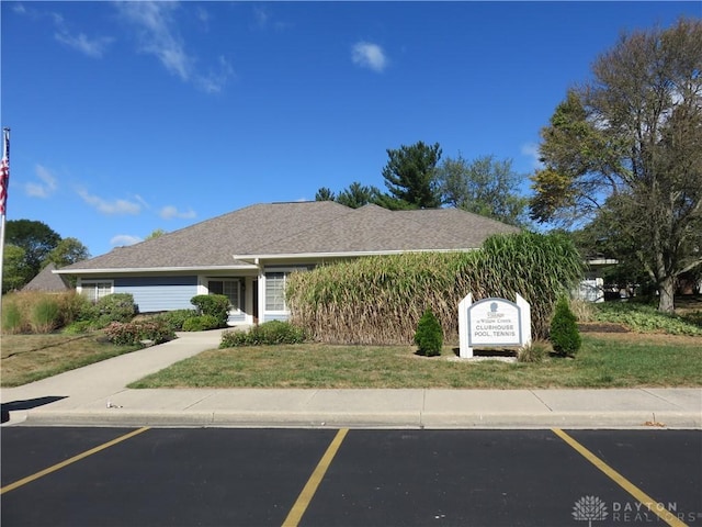 view of front of house featuring uncovered parking and a front yard