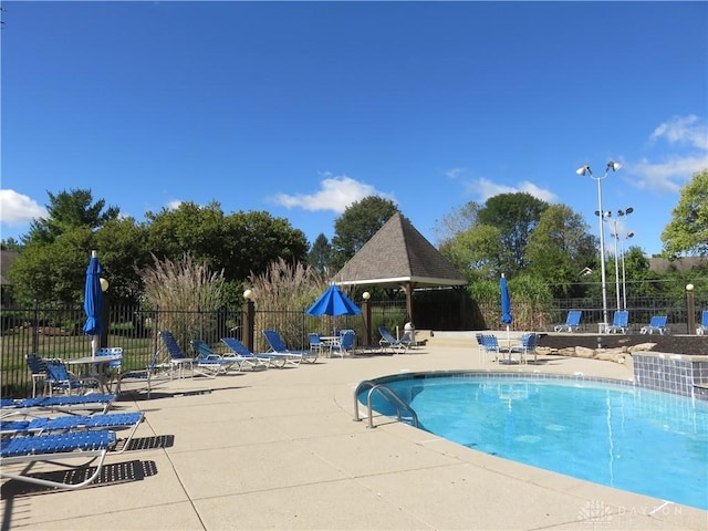 community pool featuring fence and a patio