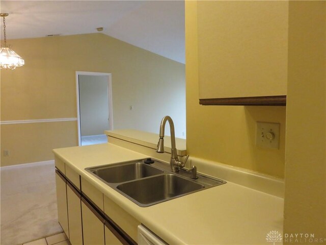 kitchen featuring light tile patterned flooring, pendant lighting, lofted ceiling, and sink