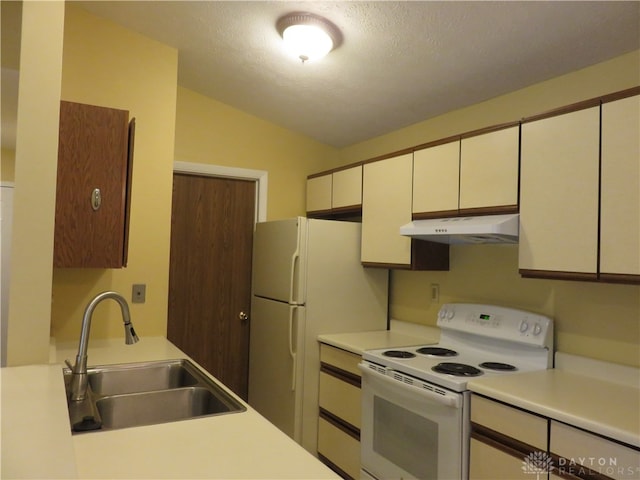 kitchen with a textured ceiling, white appliances, sink, and vaulted ceiling