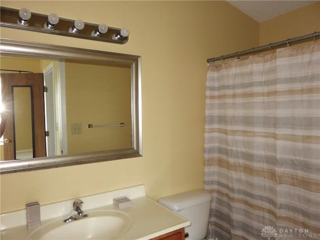 full bath featuring toilet, curtained shower, and vanity