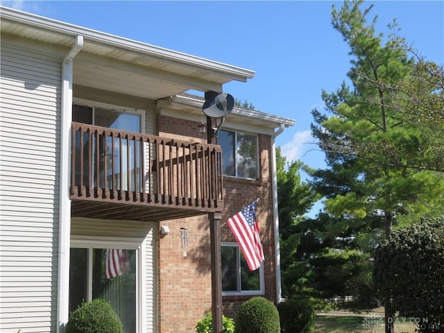 view of home's exterior with brick siding and a balcony