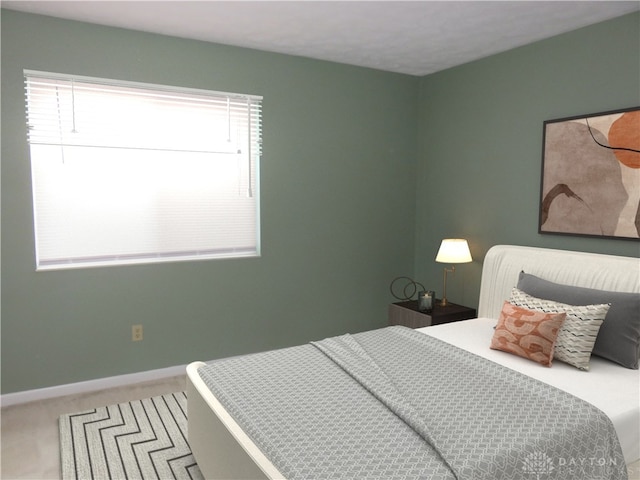 carpeted bedroom featuring multiple windows and baseboards