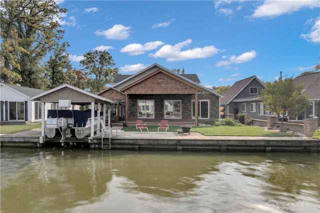 rear view of house with a water view, a patio, and a yard