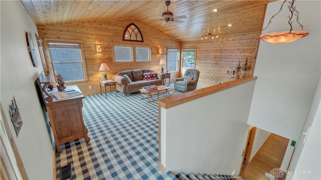 living room featuring ceiling fan, wooden ceiling, lofted ceiling, and wooden walls