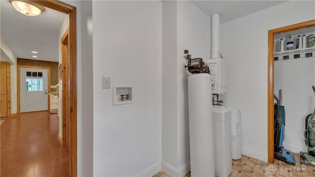 corridor with light hardwood / wood-style flooring and water heater