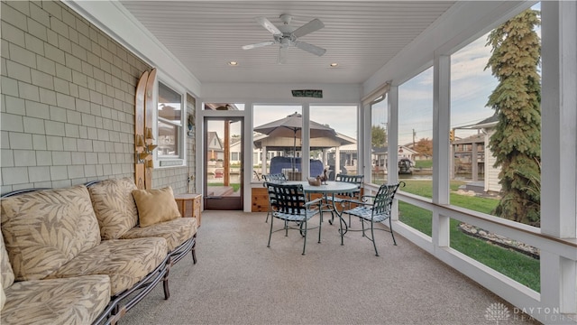 sunroom / solarium featuring a healthy amount of sunlight and ceiling fan