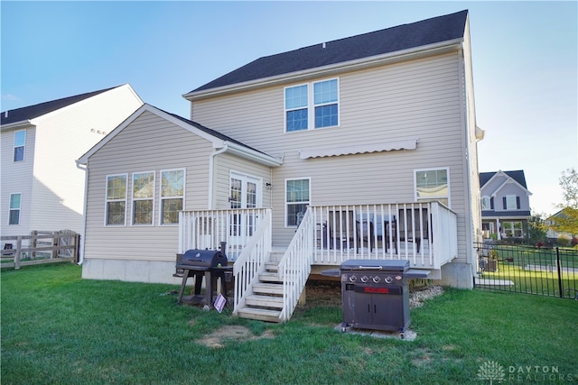 back of house featuring a lawn and a deck