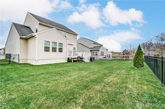 back of property featuring a playground, a deck, and a lawn