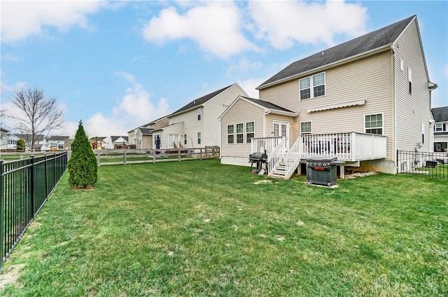 rear view of property featuring a deck and a yard