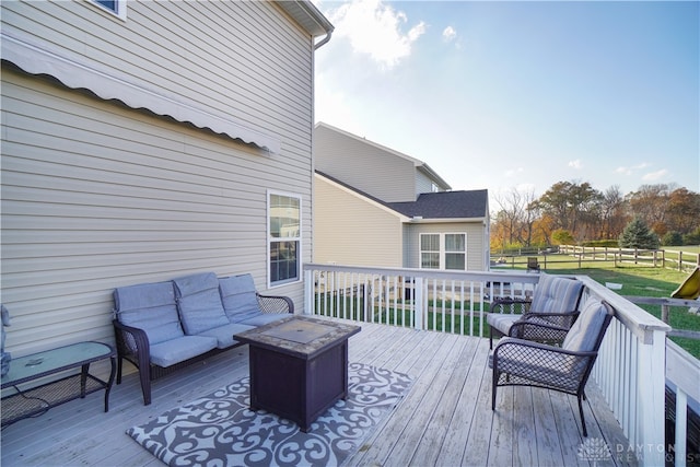 wooden deck featuring a yard and an outdoor living space with a fire pit