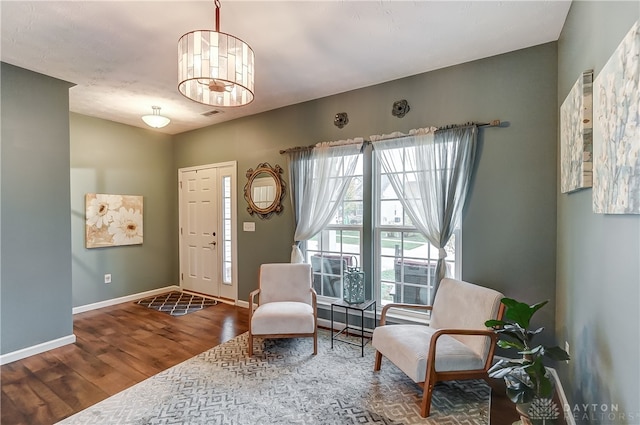 living area featuring a chandelier and hardwood / wood-style flooring