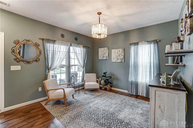 living area with dark hardwood / wood-style flooring and a notable chandelier