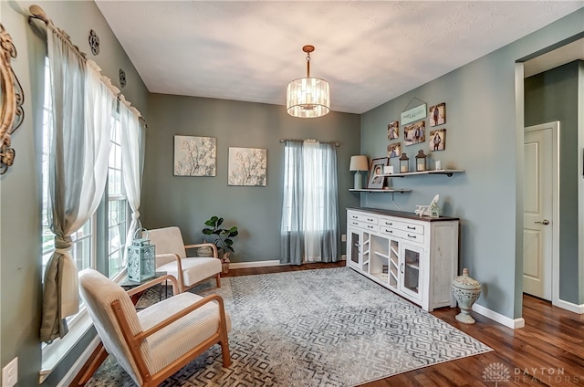 living area with hardwood / wood-style floors and an inviting chandelier