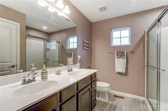 bathroom with a healthy amount of sunlight, a shower with shower door, and toilet