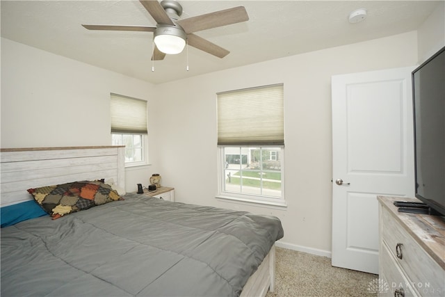 carpeted bedroom with ceiling fan and multiple windows