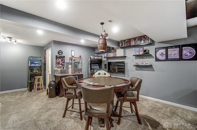 carpeted dining area featuring bar and track lighting