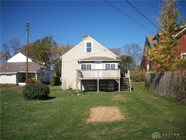 back of property with stairs, fence, a lawn, and a wooden deck