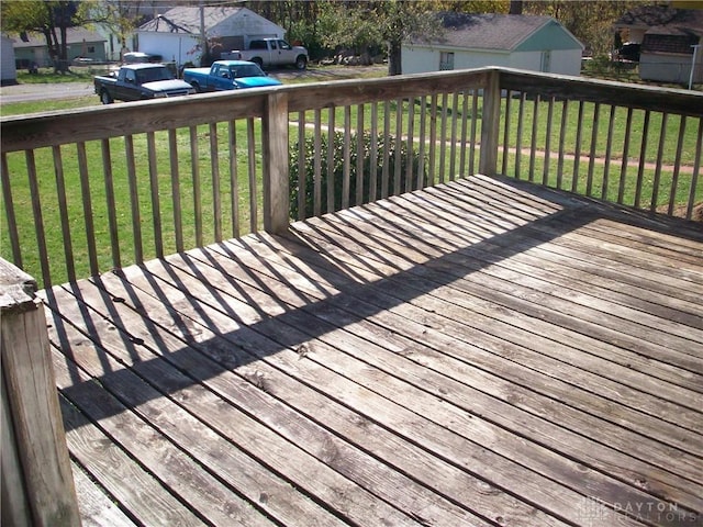 wooden terrace featuring a residential view and a yard