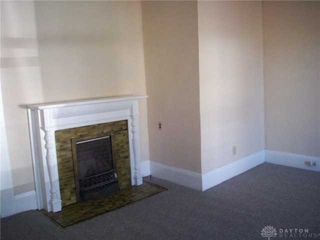 unfurnished living room featuring a glass covered fireplace, carpet flooring, and baseboards