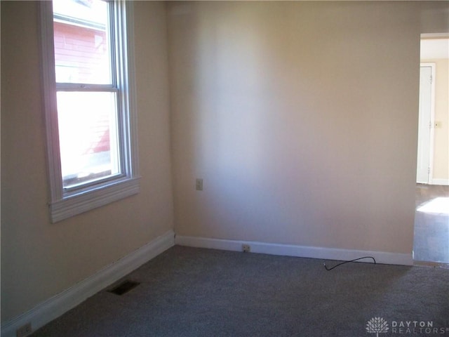 unfurnished room featuring carpet flooring, visible vents, and baseboards