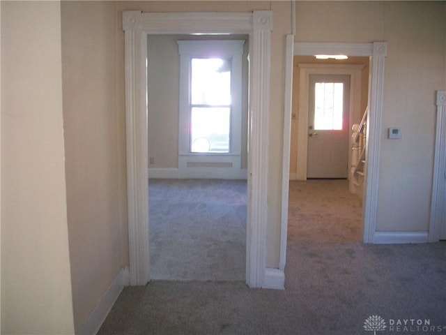 hallway with carpet floors and baseboards