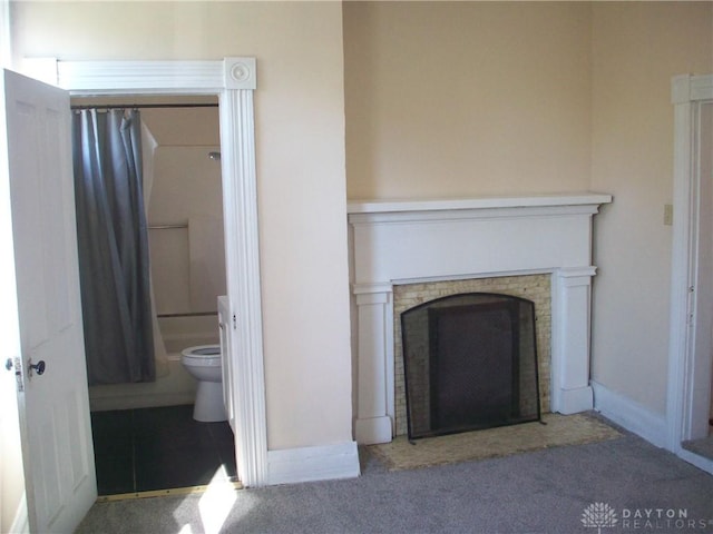 unfurnished living room with a brick fireplace, carpet flooring, and baseboards