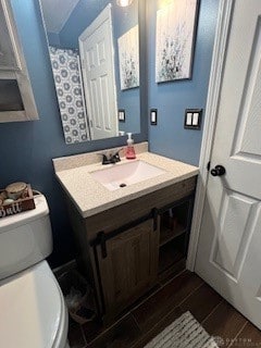 bathroom featuring vanity, wood-type flooring, and toilet