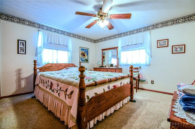 carpeted bedroom featuring multiple windows and ceiling fan