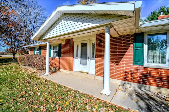 view of exterior entry featuring covered porch