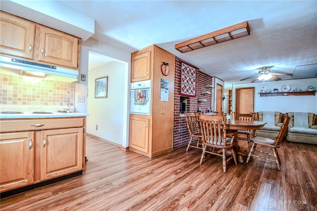 dining space with light hardwood / wood-style flooring, brick wall, and ceiling fan