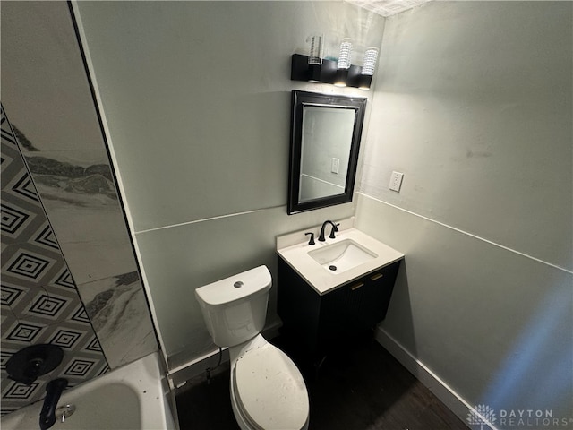 bathroom featuring toilet, vanity, and a bath