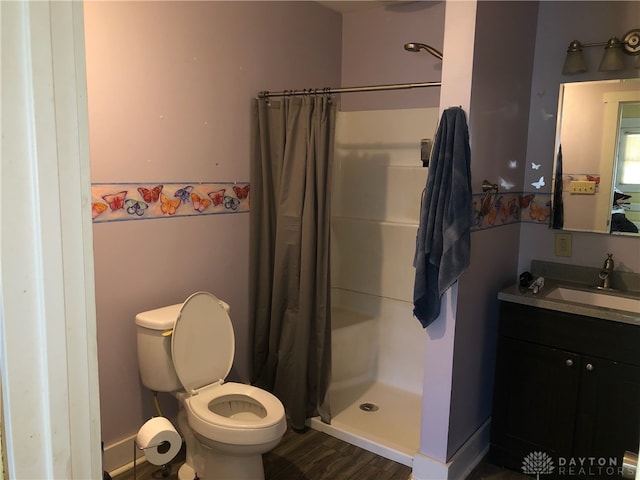 bathroom featuring walk in shower, vanity, toilet, and wood-type flooring