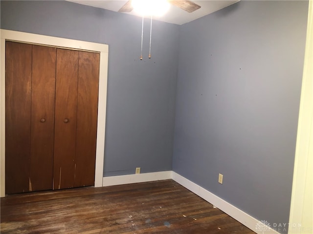 unfurnished bedroom with dark hardwood / wood-style floors, ceiling fan, and a closet