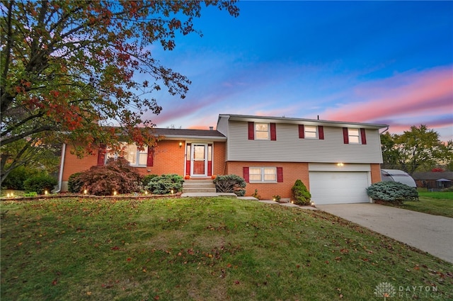 split level home with a garage and a yard