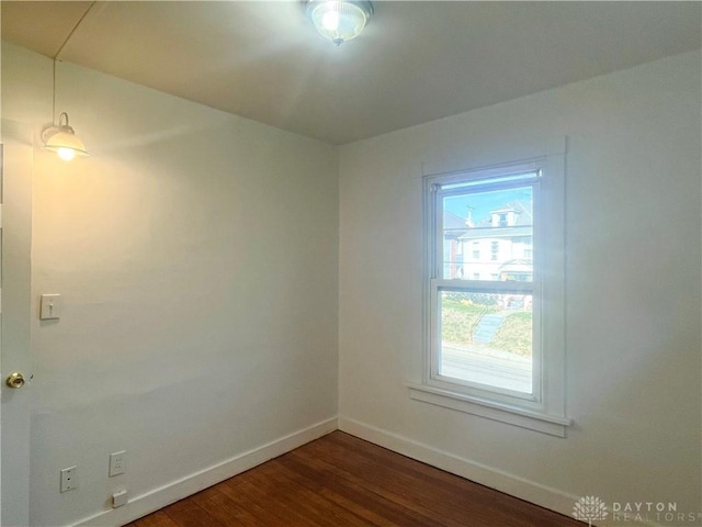 empty room with dark hardwood / wood-style flooring