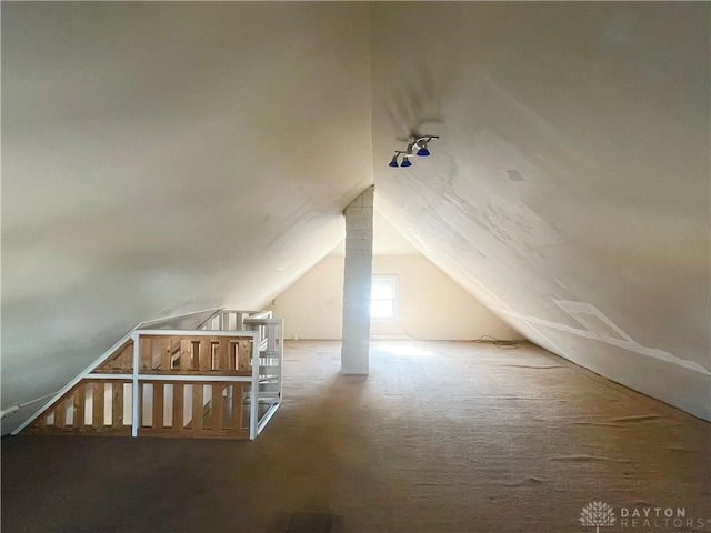 additional living space featuring lofted ceiling and carpet