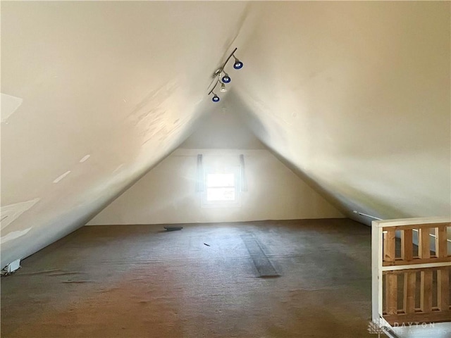 bonus room featuring dark carpet and vaulted ceiling